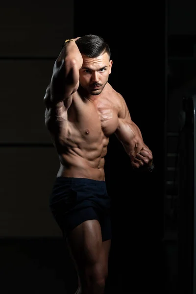 Jeune bodybuilder flexion des muscles Pose poitrine latérale — Photo