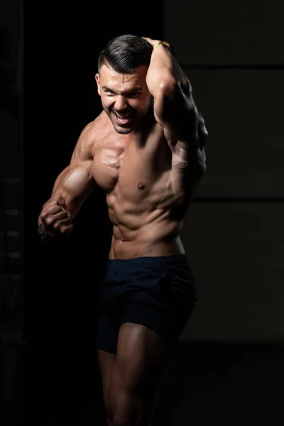 Bodybuilder presterende kant borst vormen — Stockfoto
