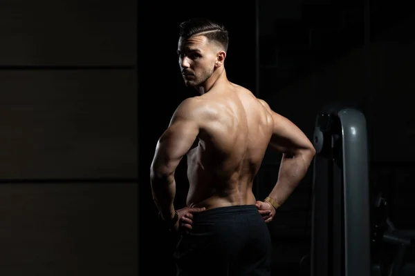 Svalnatý muž protahuje zádové svaly pozice — Stock fotografie