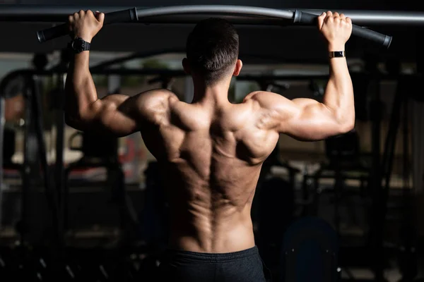 Manliga idrottare gör pull ups — Stockfoto