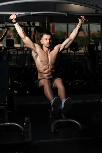 Atleet uitvoeren Hanging Leg Raises oefening Ab oefeningen — Stockfoto
