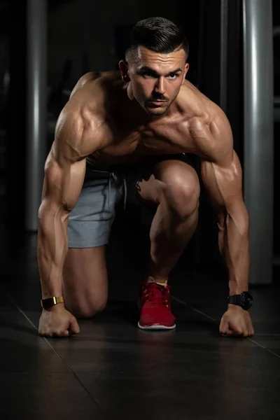 Starka muskulösa män knä på golvet — Stockfoto