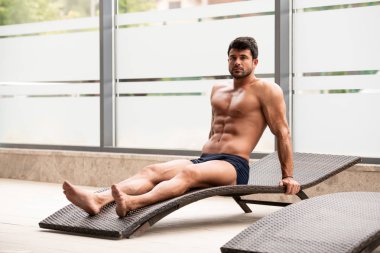 Bir güneşlenme üzerinde yatan genç adam