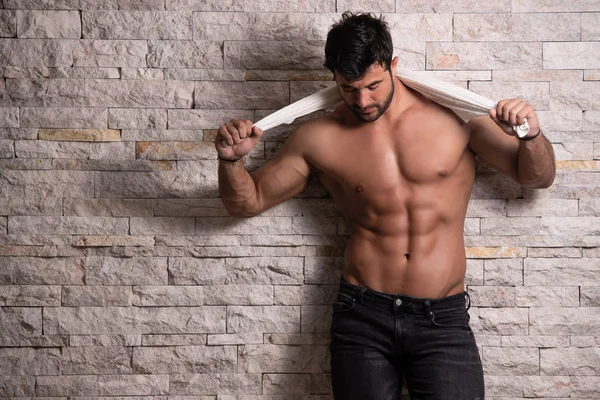 Model Flexing Muscles Near the Brick Wall — Stock Photo, Image