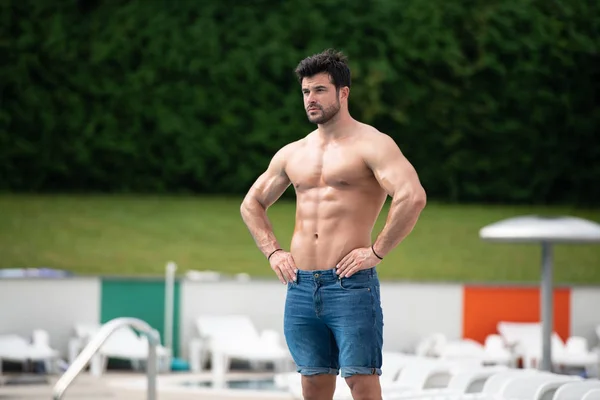 Jeune homme Macho regardant à la piscine extérieure — Photo