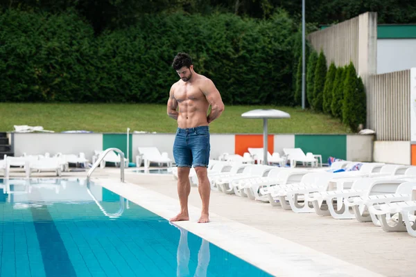 Jeune homme Macho regardant à la piscine extérieure — Photo