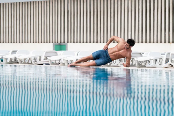 Jeune homme Macho regardant à la piscine extérieure — Photo