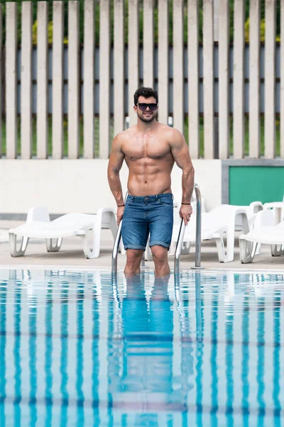 Giovane uomo muscolare a piscina all'aperto — Foto Stock