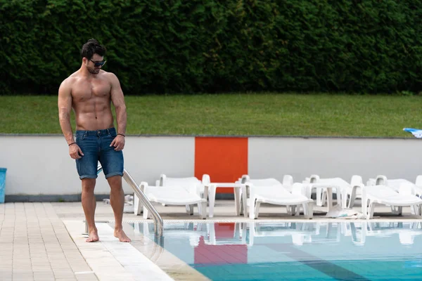 Jovem procurando o homem machista na piscina ao ar livre — Fotografia de Stock