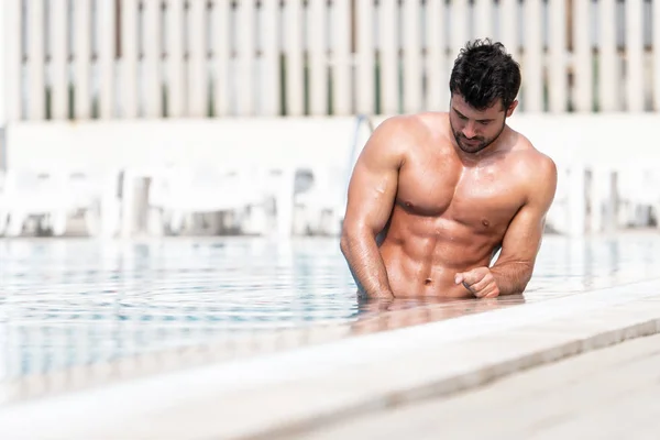 Mladá Macho muž při pohledu na plavecký venkovní bazén — Stock fotografie