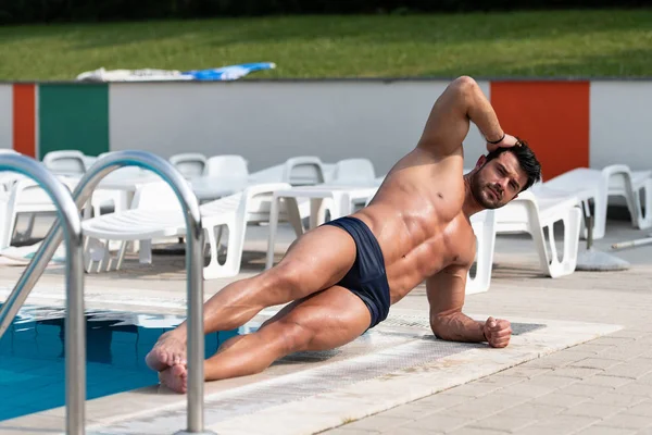 Svalnatý mladík na plavecký venkovní bazén — Stock fotografie