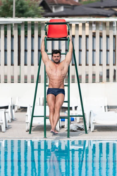 Joven mirando salvavidas hombre en la piscina al aire libre — Foto de Stock