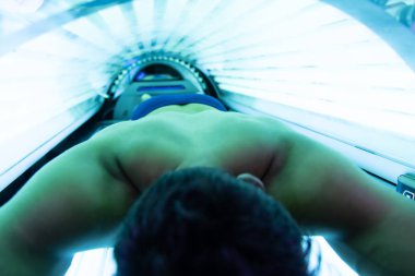 Solaryum güzellik salonları içinde genç kaslı adam