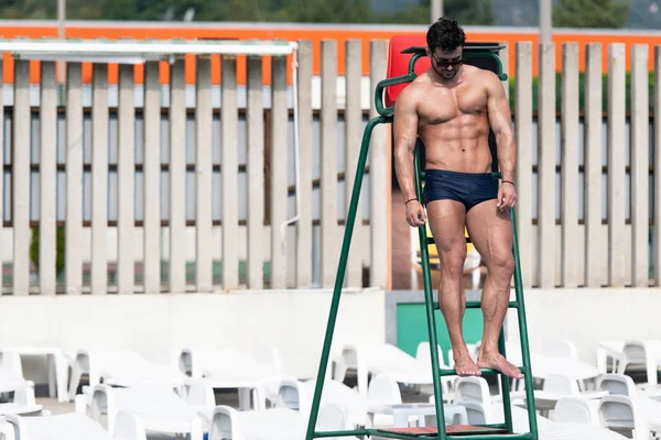 Joven mirando salvavidas hombre en la piscina al aire libre —  Fotos de Stock