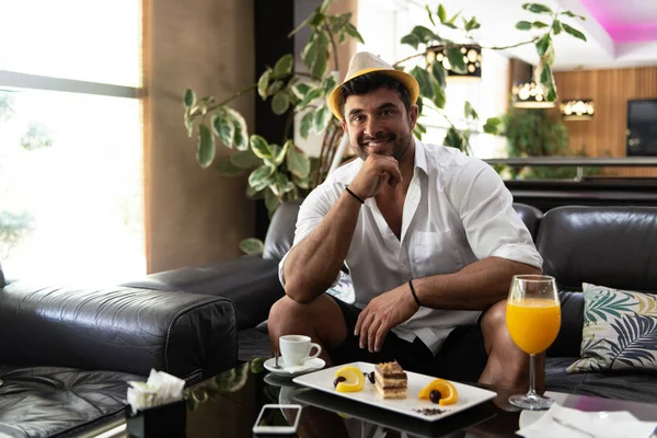 Homem relaxante no sofá no bar do lobby do hotel — Fotografia de Stock