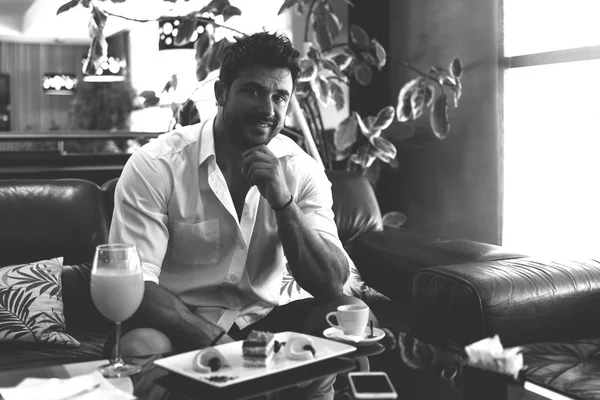 Man Relaxing on Sofa in Hotel Lobby Bar