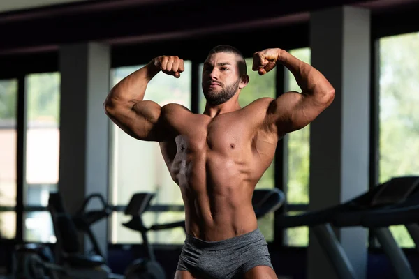 Bodybuilder presterende achterste dubbele biceps vormen — Stockfoto