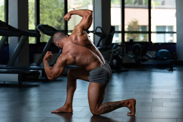 Gespierde mannen raakt achterste dubbele biceps pose — Stockfoto