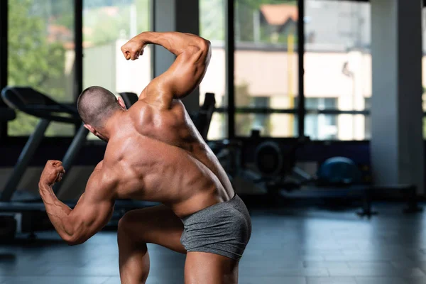 Izmos férfiak üti hátsó dupla bicepsz póz — Stock Fotó