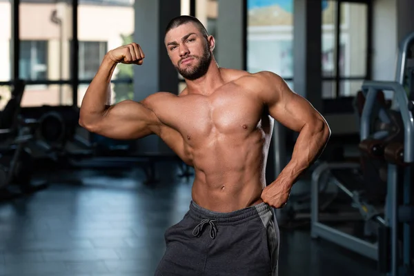 Homem muscular está batendo Bicep Pose traseira — Fotografia de Stock