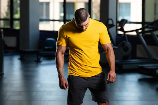 Homem muscular posando em camiseta amarela — Fotografia de Stock