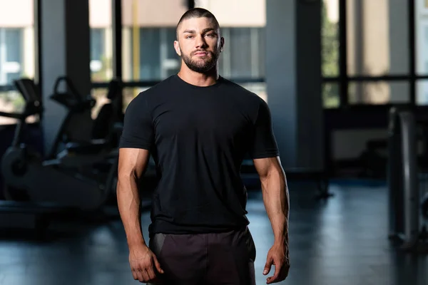 Muskulös man poserar i svart T-shirt — Stockfoto