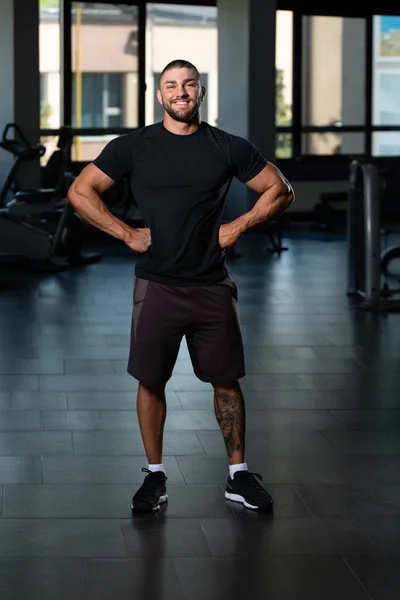 М'язистий чоловік позує в чорній футболці — стокове фото