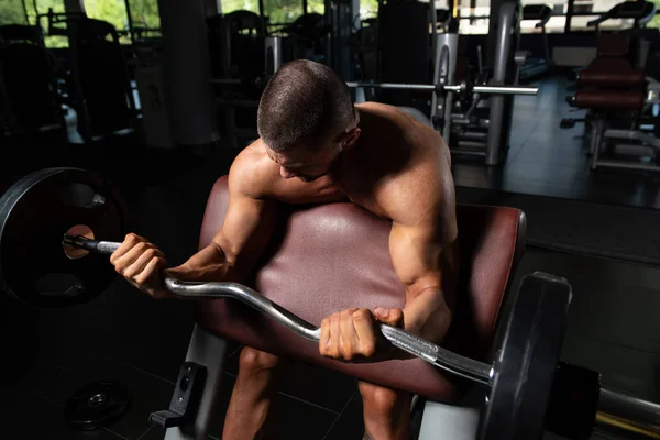 Exercício de bíceps com Barbell em um ginásio — Fotografia de Stock