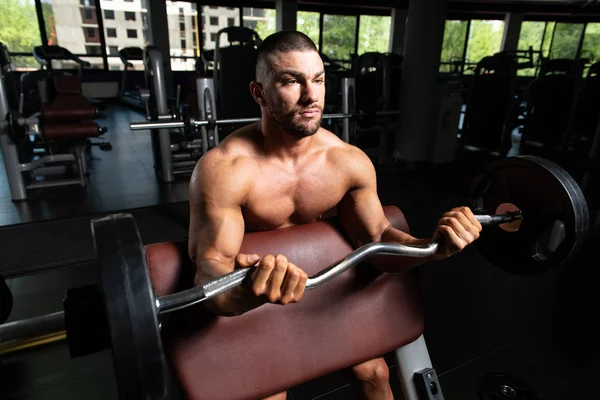 Exercício de bíceps com Barbell em um ginásio — Fotografia de Stock