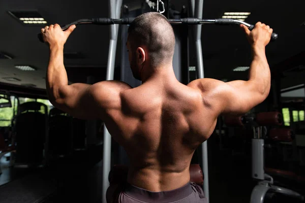 Culturista haciendo ejercicio de vuelta en el gimnasio — Foto de Stock