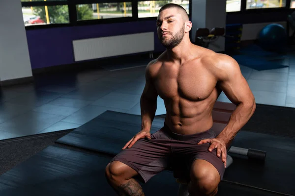 Homem muscular após o exercício descansando no ginásio — Fotografia de Stock