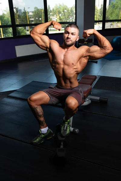 Bodybuilder presterende achterste dubbele biceps vormen — Stockfoto