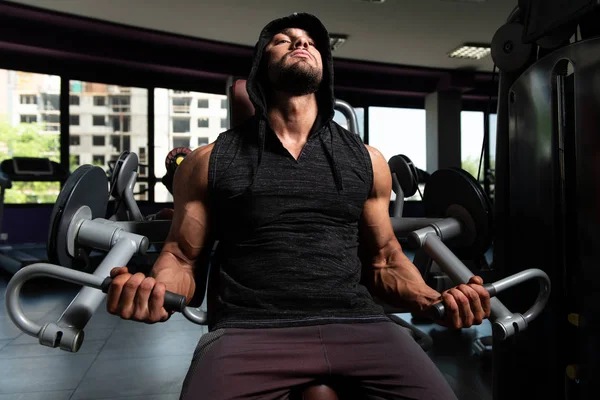 Uomo con cappuccio Esercizio Bicipiti in palestra — Foto Stock