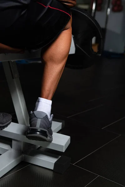 Bonito homem exercitando bezerros no centro de fitness — Fotografia de Stock