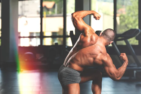 Izmos ember az ütő hátsó dupla bicepsz póz — Stock Fotó