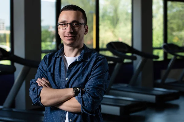 Debole ragazzo nerd con occhiali in centro fitness — Foto Stock