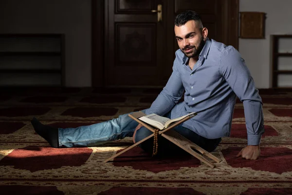 Hombre musulmán leyendo el Sagrado Libro Islámico Corán — Foto de Stock