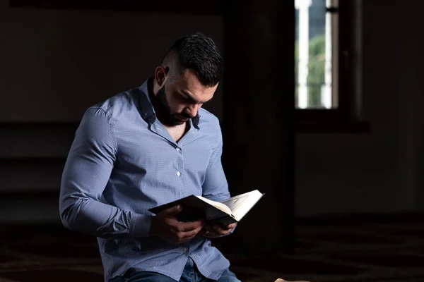 イスラム教徒の男性は、コーランを読んでください。 — ストック写真