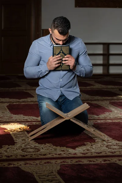 Attraktiver muslimischer Kerl küsst den Koran — Stockfoto