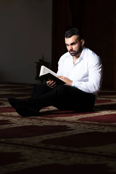 Hombre musulmán leyendo el Sagrado Libro Islámico Corán — Foto de Stock