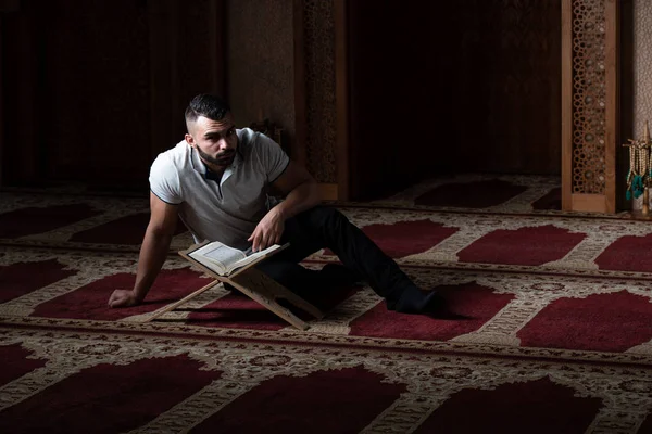 Hombre musulmán leyendo el Sagrado Libro Islámico Corán — Foto de Stock