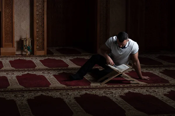 Привлекательный мусульманский парень, читающий Коран — стоковое фото