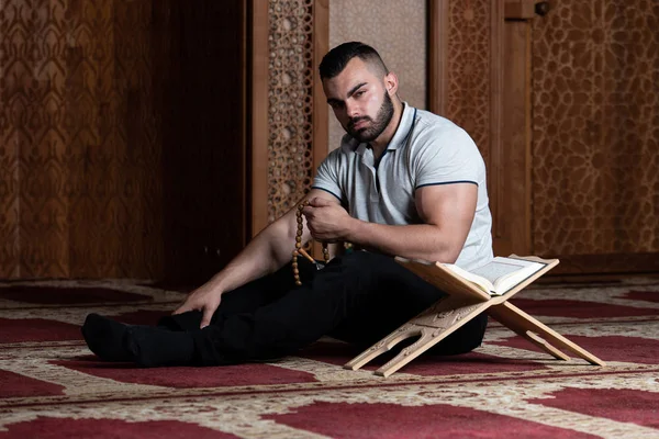 Attraktiver muslimischer Kerl beim Lesen des Korans — Stockfoto