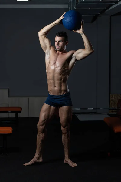 Bodybuilder Flexing Muscles With Medicine Ball — ストック写真