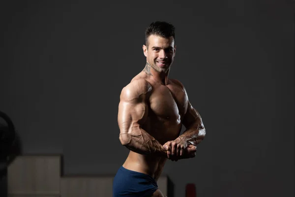 Junger Bodybuilder lässt Muskeln an der Seite der Brust spielen — Stockfoto