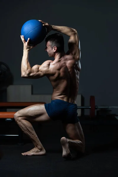 Bodybuilder Flexing Muscles With Medicine Ball — ストック写真