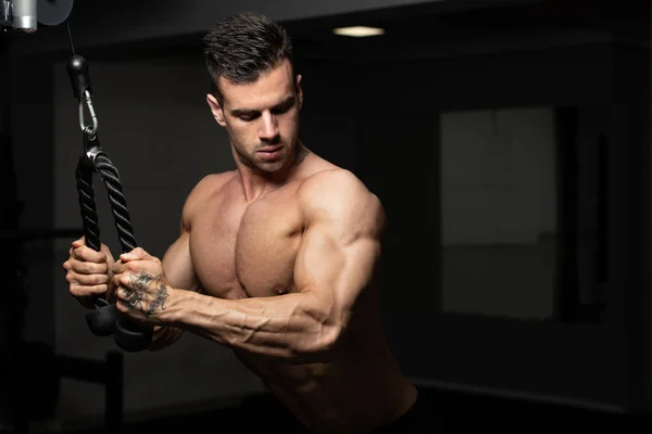 Bodybuilder macht schwere Übungen für Trizeps mit Seil — Stockfoto