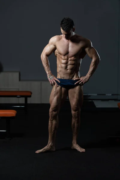 Όμορφος μυώδης άνδρας λύγισμα των μυών στο γυμναστήριο — Φωτογραφία Αρχείου