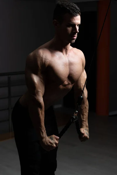 Bodybuilder macht schwere Übungen für Trizeps mit Seil — Stockfoto