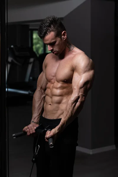 Hombre ejercitando bíceps en el gimnasio — Foto de Stock